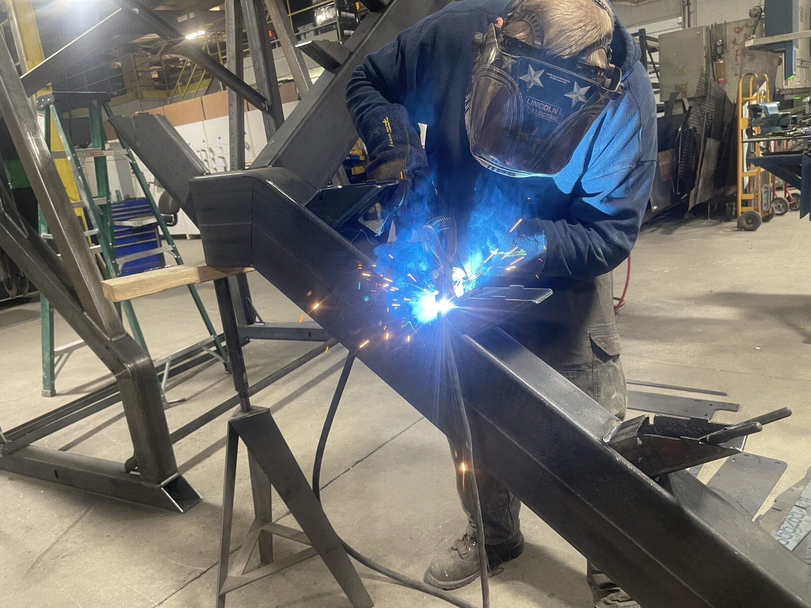 Inside the High Road Manufacturing shop floor — welders at work, CNC fabrication equipment, and large-format production bays at the Ponderay, Idaho facility